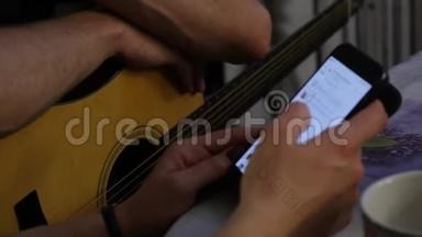特写双手练习弹吉他，双手拿着手机。 4K